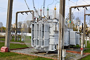 Large industrial iron metal transformer substation with transformers and high-voltage electrical equipment and wires with surge