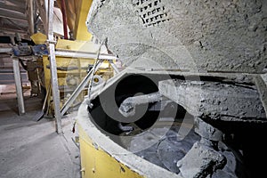 Large industrial mixer, for mixing ingredients into liquid cement.. Workers in the workshop of the House-building plant