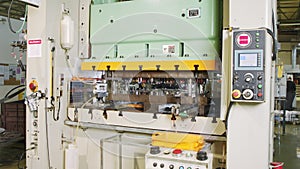 A large industrial punch press forming high precision metal parts for the automotive industry