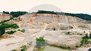 Large industrial sand quarry at the edge of the forest. Remains of sand from a height. Large-scale sand quarry.