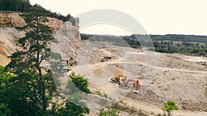 Large industrial sand quarry. Equipment that works in a sand quarry. The mountain from which sand is extracted