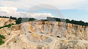 Large industrial sand quarry. Equipment that works in a sand quarry. The mountain from which sand is extracted