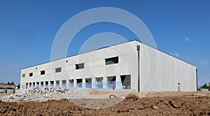 Large industrial warehouse made of prefab concrete blocks, under construction.