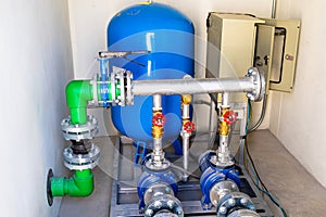 Large industrial water treatment and boiler room. Shiny steel metal pipes and blue pumps and valves. interior of a modern gas boil