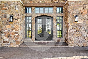 A large, iron door on a stone house.