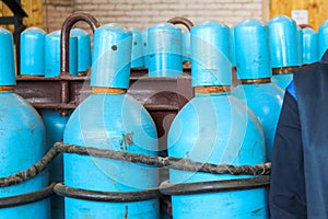 Large iron metal blue gas cylinders with oxygen, air, helium under excessive internal pressure to store compressed, liquefied and