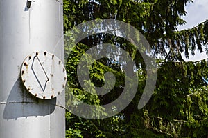 Large iron metal stainless brilliant industrial tank column with a folding round hatch, manhole with bolts, nuts and studs