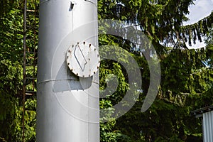 Large iron metal stainless brilliant industrial tank column with a folding round hatch, manhole with bolts, nuts and studs against