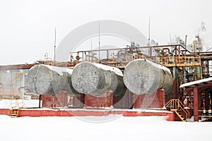 Large iron tanks, ladders and protective fencing pipes equipment and machine tools valves heat exchangers at a petroleum refining