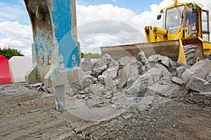 Large jackhammer crushing asphalt paving during road works