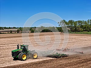 Large John Deere tractor pulling a John Deere disk cultivator
