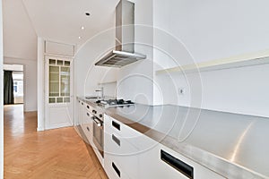 a large kitchen with white cabinets and stainless steel counters