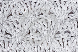 Large knitting of a white wool sweater. Texture and background