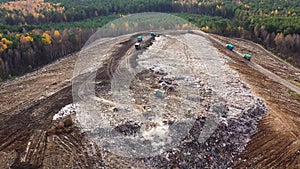 Large landfill with garbage trucks, top view.