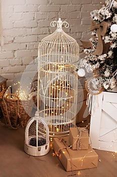 Large lanterns with lights glowing garlands and gifts stand on floor in room. Christmas living room is decorated with lanterns. Wo