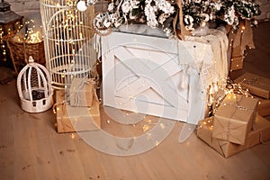 Large lanterns with lights glowing garlands and gifts stand on floor in room. Christmas living room is decorated with lanterns. Wo