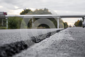 A large layer of fresh hot asphalt. Layer of asphalt raw material in a shallow depth of field. Rollers rollin fresh hot