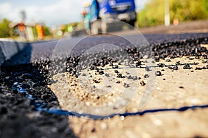 A large layer of fresh hot asphalt. Road construction. Construction of a new road