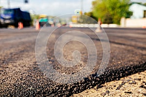 A large layer of fresh hot asphalt. Road construction. Construction of a new road