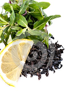 A large leaf black tea, fresh mint and a slice of lemon on a white background