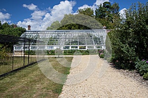 Large lean-to greenhouse in an English country garden