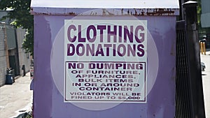 large light purple metal bin with sign that says clothing donations no dumping