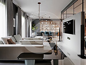 Large living room with a large white corner sofa and TV unit, dining area with dining table. Gray walls and large windows