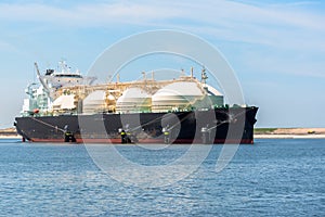 Large LNG carrier ship in a harbour on a sunny summer day