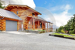 Large log cabin with porch and garage.