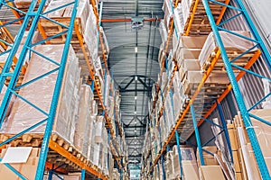 Large Logistics hangar warehouse with lots shelves or racks with pallets of goods. Industrial shipping