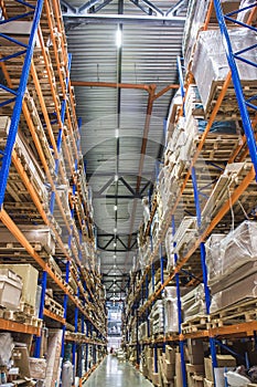 Large Logistics hangar warehouse with lots shelves or racks with pallets of goods. Industrial shipping and cargo delivery