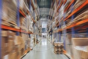 Large Logistics hangar warehouse with lots shelves or racks with pallets of goods, perspective with motion blur effect