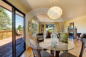 Large long living room with dining room table, balcony and fireplace.