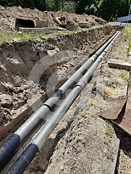 A large long pit with old pipes at the bottom during the elimination of the accident and their replacement