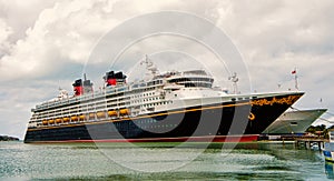 Large luxury cruise ship Disney Wonder on sea water and cloudy sky background docked at port of Nassau, Bahamas