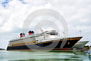 Large luxury cruise ship Disney Wonder on sea water and cloudy sky background docked at port of Nassau, Bahamas