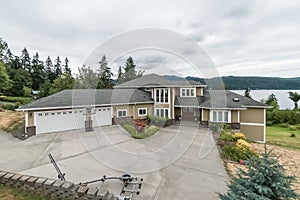 Large luxury waterfront home multi-level huge driveway overcast