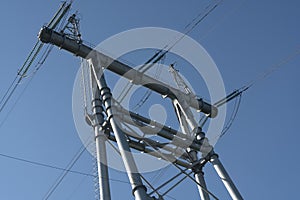 Large massive metal electric pole on four supports.