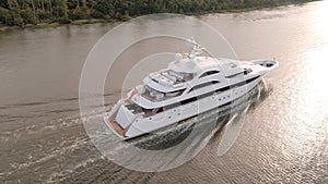 Large mega yacht underway along the coast, low aerial view