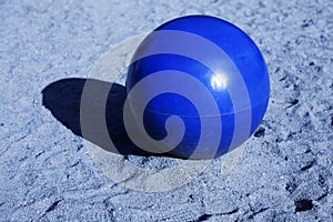 A large metal ball in blue sand