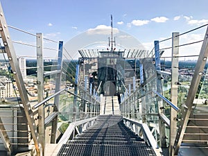 Large metal chrome shiny stairs with railings on the roof of a glass skyscraper, a tall building with a panoramic view of city