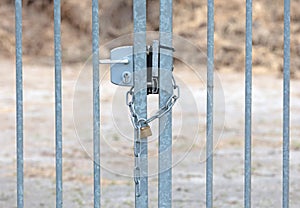 Large metal fence locked with a padlock and a chain