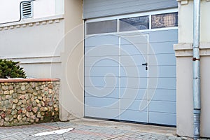 Large metal garage doors. Modern automatic garage door. Closed roller gates. Safe storage of the car