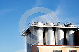 Large metal industrial containers on blue sky background