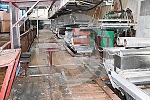 Large metal rollers rolls with teeth of the gears of the production line, a conveyor belt in the workshop at a industrial chemical