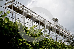 Large Metal Scaffolding Amidst Green Foliage Under Overcast Sky