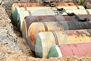 Large metal tanks are buried in the ground in the production war