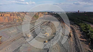 Large mining dump truck near the open quarry aerial view.