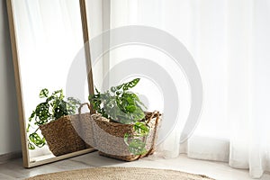 Large mirror with wooden frame near window in room