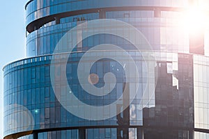 Large modern glass-metal building. Business offices in a skyscraper. Reflection of the sky in a glass facade